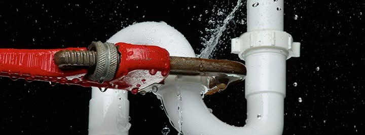S-Curve Water pipe leaking and a pipe wrench trying to tighten connector.