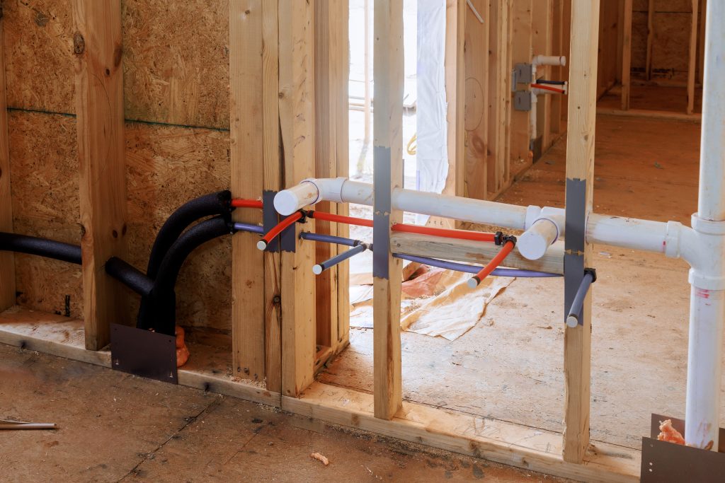 House construction wall frame with plumbing pipes